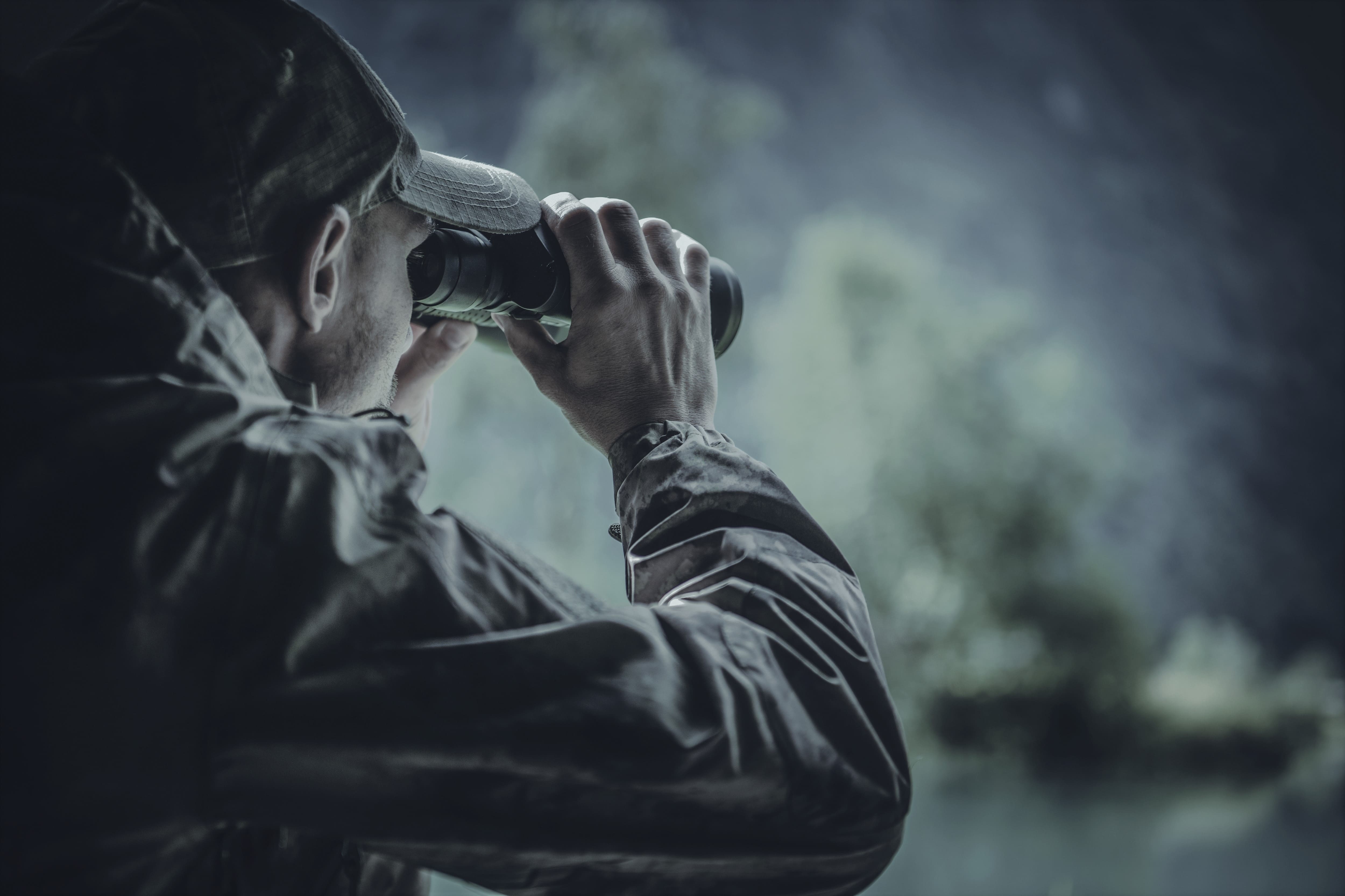 A man observes nature through binoculars.