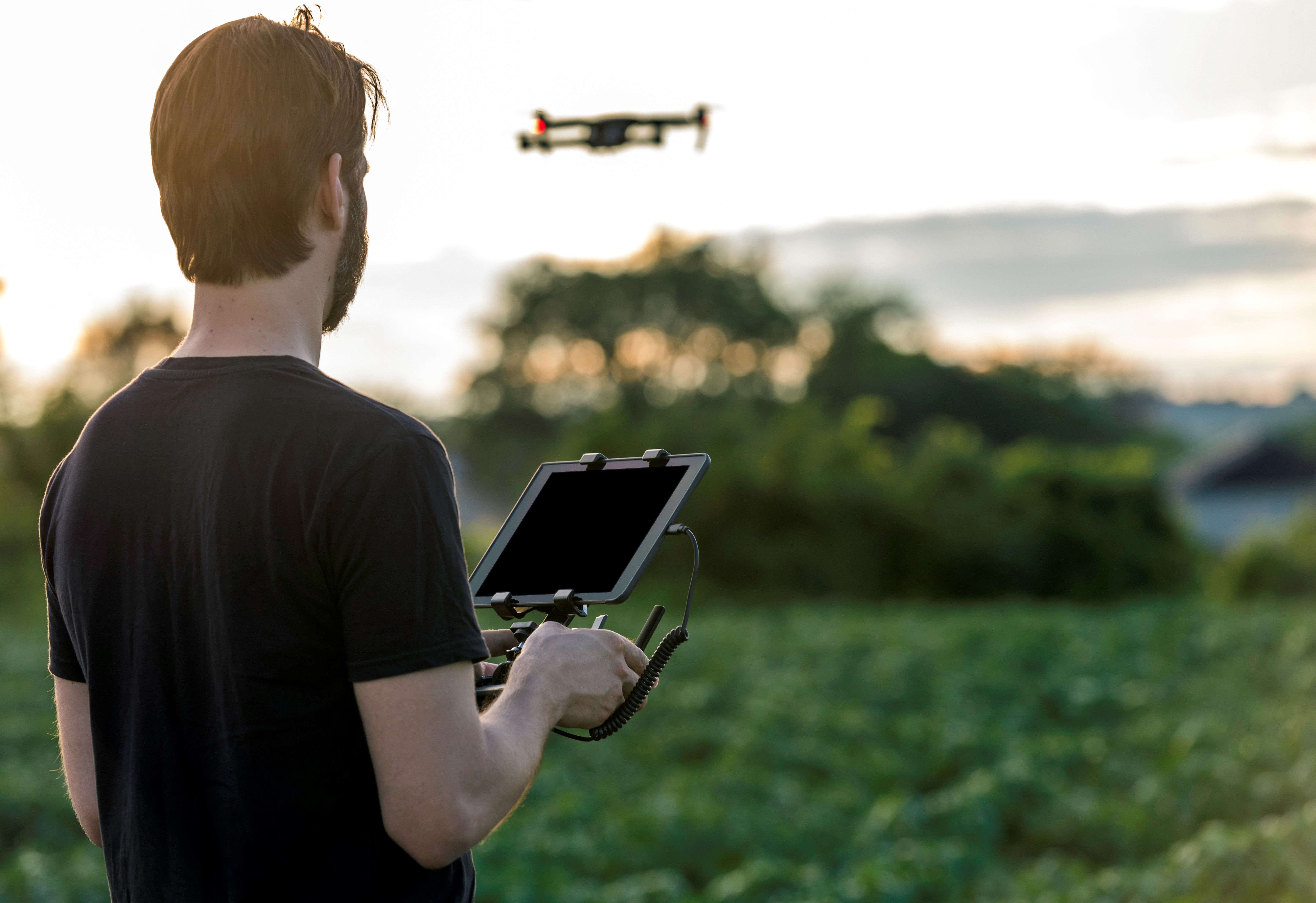 A man pilots a drone for crop monitoring